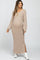 woman wearing a light beige ribbed maternity maxi dress with long sleeves and side slits, showing her baby bump