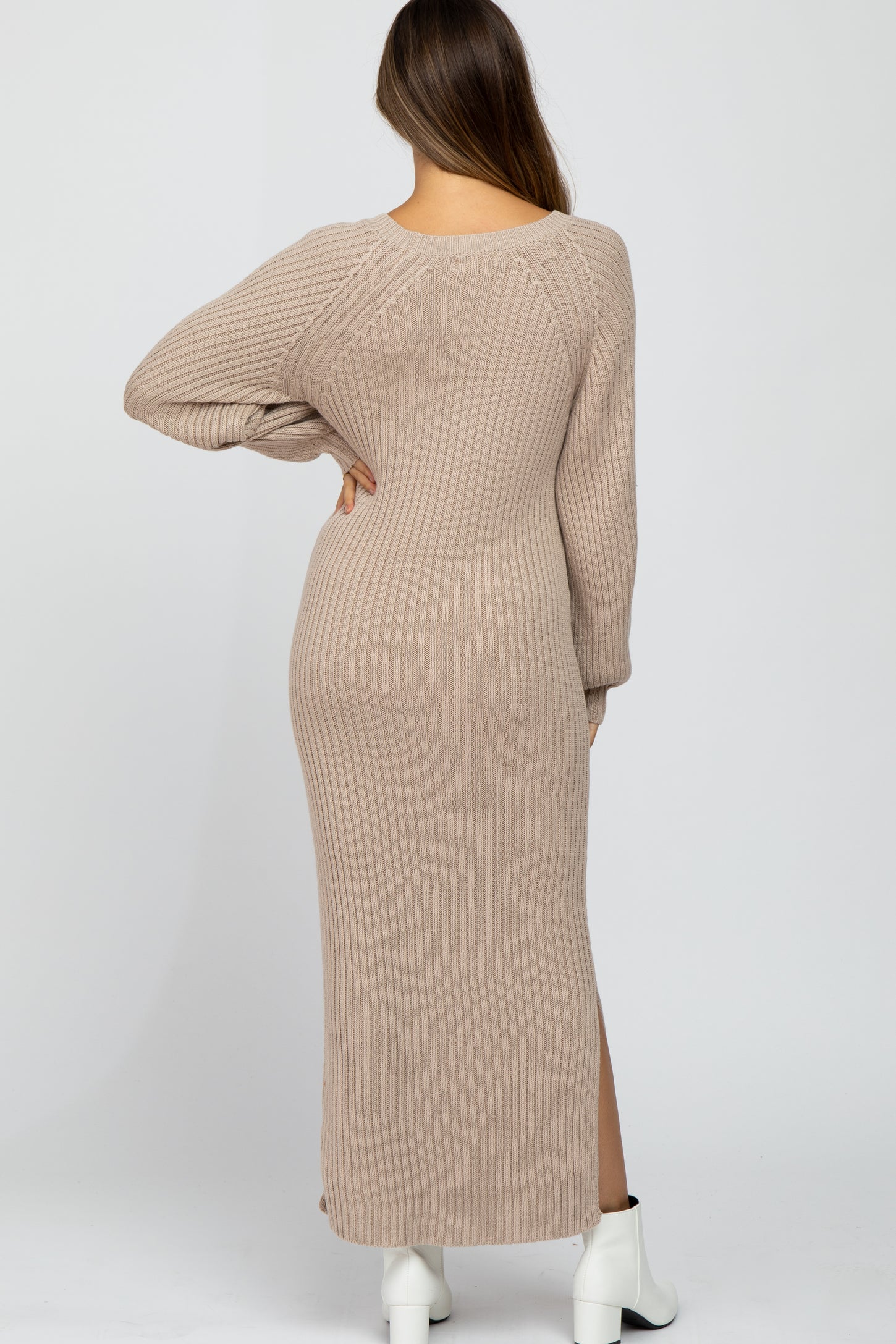 woman wearing a beige ribbed maternity maxi dress with long sleeves and side slits