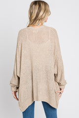 woman wearing a beige oversized knitted cardigan sweater with a loose fit and batwing sleeves