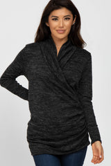 woman wearing a dark grey long sleeve wrap top with gathered detail, styled with blue jeans