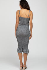 woman wearing a black and white striped fitted midi dress with ruffle hem and spaghetti straps