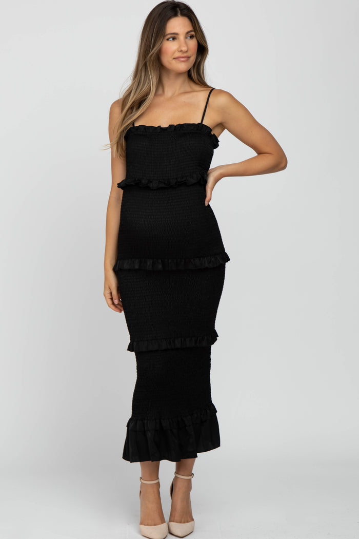 woman wearing a black maternity dress with ruffle details and spaghetti straps, fitted silhouette