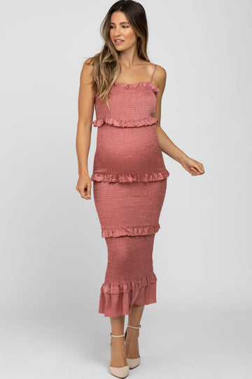woman wearing a dusty rose maternity dress with ruffle details and a fitted silhouette, showcasing her baby bump