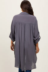 Back view of a woman wearing a long charcoal grey button down tunic shirt with pleated back detail