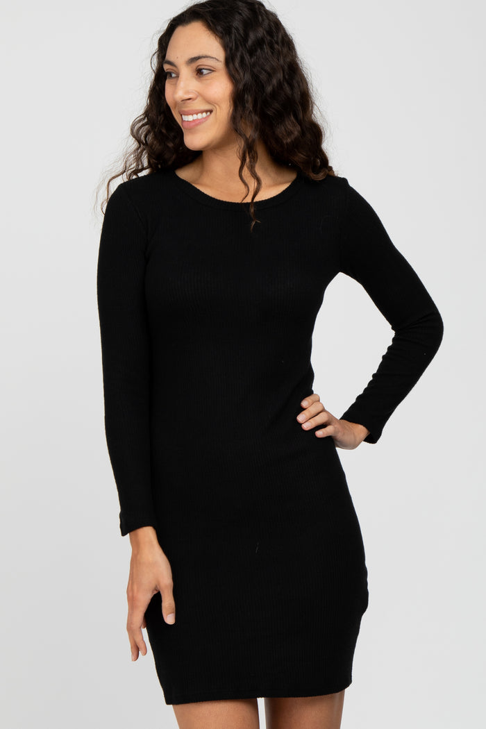 woman wearing a black ribbed long sleeve dress and smiling