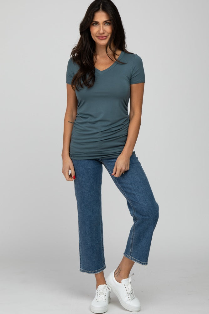 woman wearing a slate blue v-neck short sleeve top tucked into cropped jeans and white sneakers