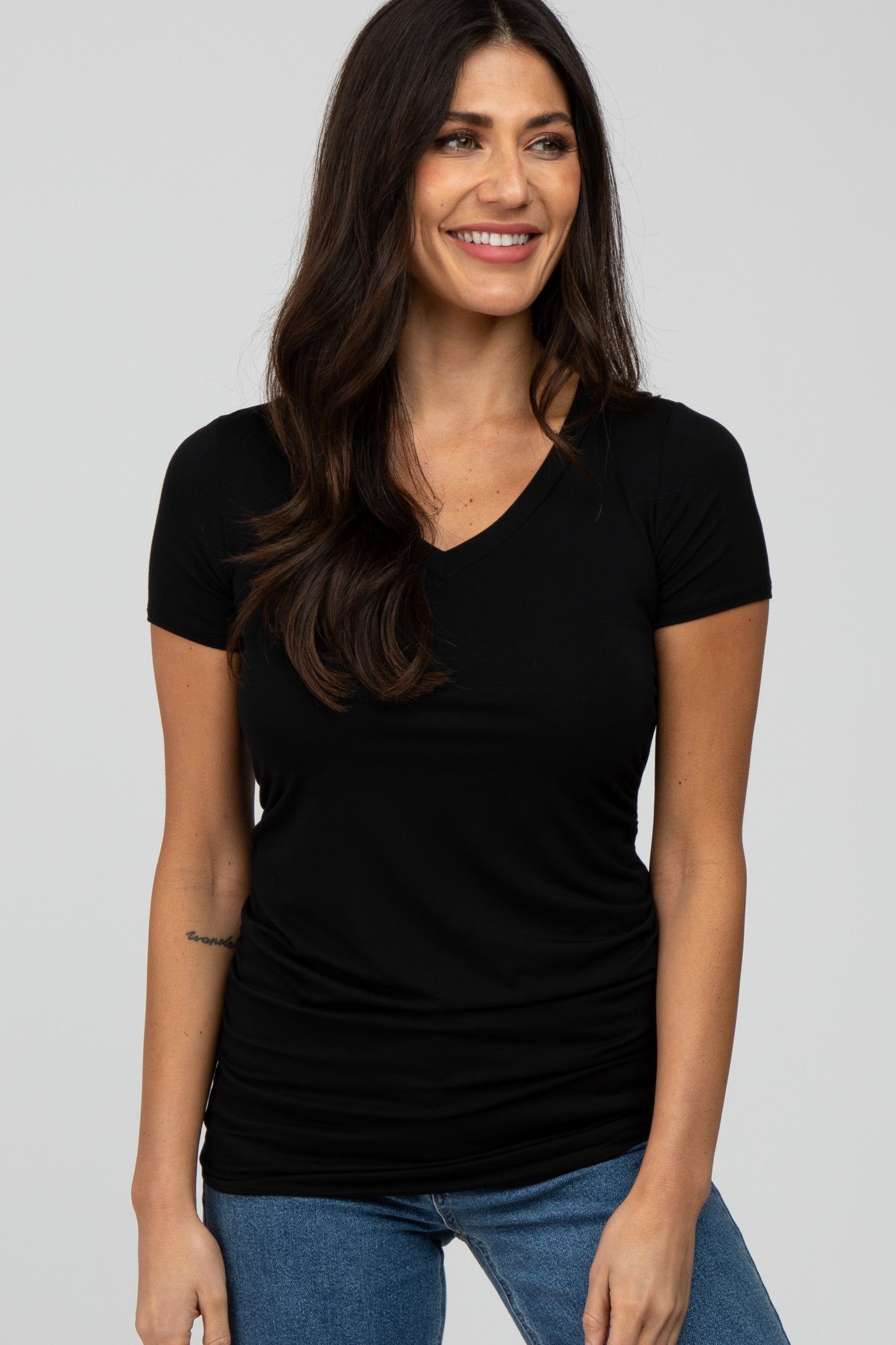 woman wearing a black short sleeve v-neck t-shirt and blue jeans