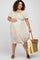 woman wearing a floral print maternity dress with a square neckline and short sleeves, holding a bag and showing her baby bump