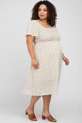 woman wearing a floral print maternity plus dress with short sleeves and a baby bump_visible