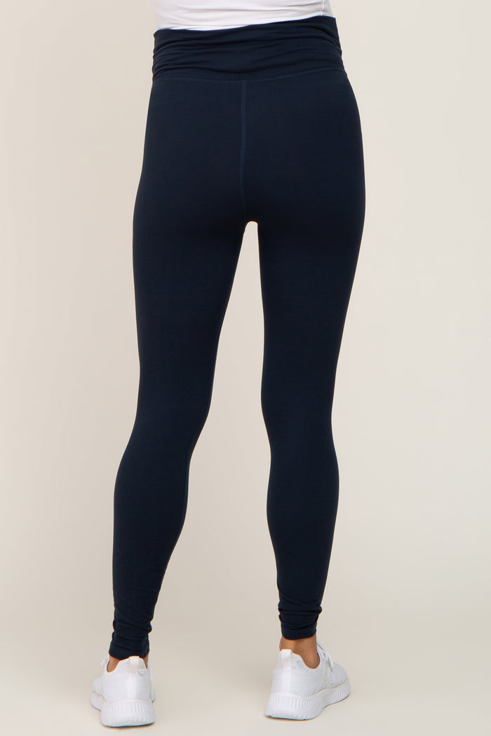 woman wearing navy blue maternity leggings with a high waist and a fitted style
