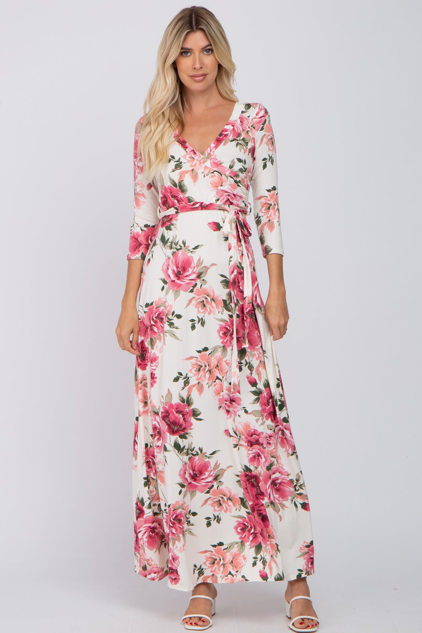 woman wearing a floral print wrap maxi dress with three-quarter sleeves and a tie at the waist