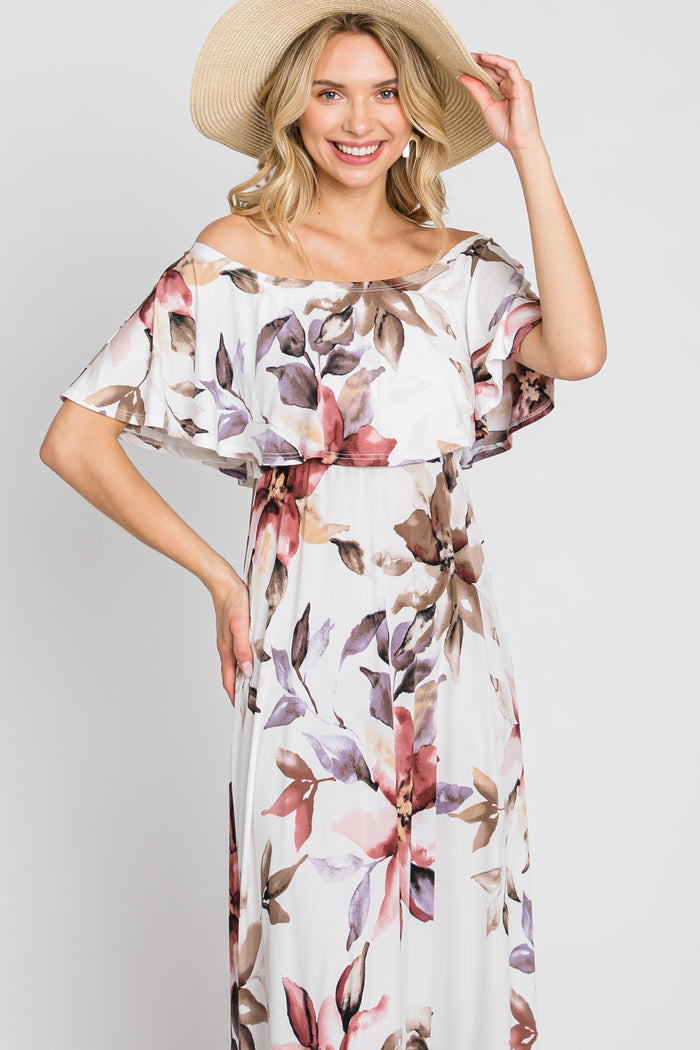 woman wearing a floral off-the-shoulder maxi dress with a flowy design and a wide-brimmed straw hat