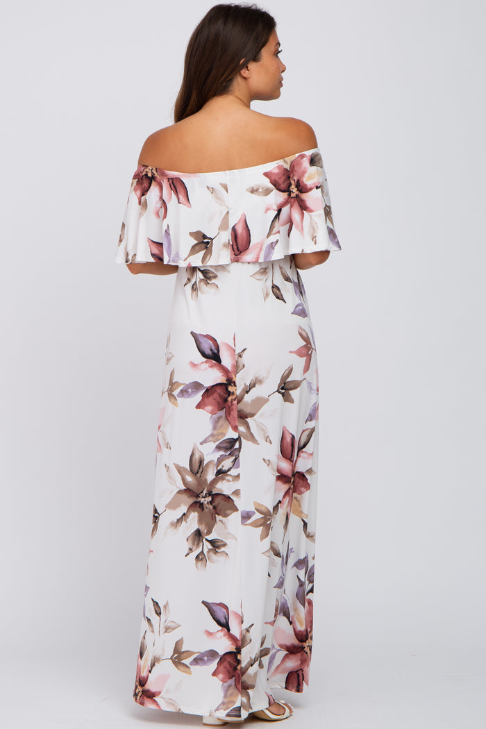 woman wearing a floral off-the-shoulder maxi dress in white with pink and mauve accents, showing a baby bump
