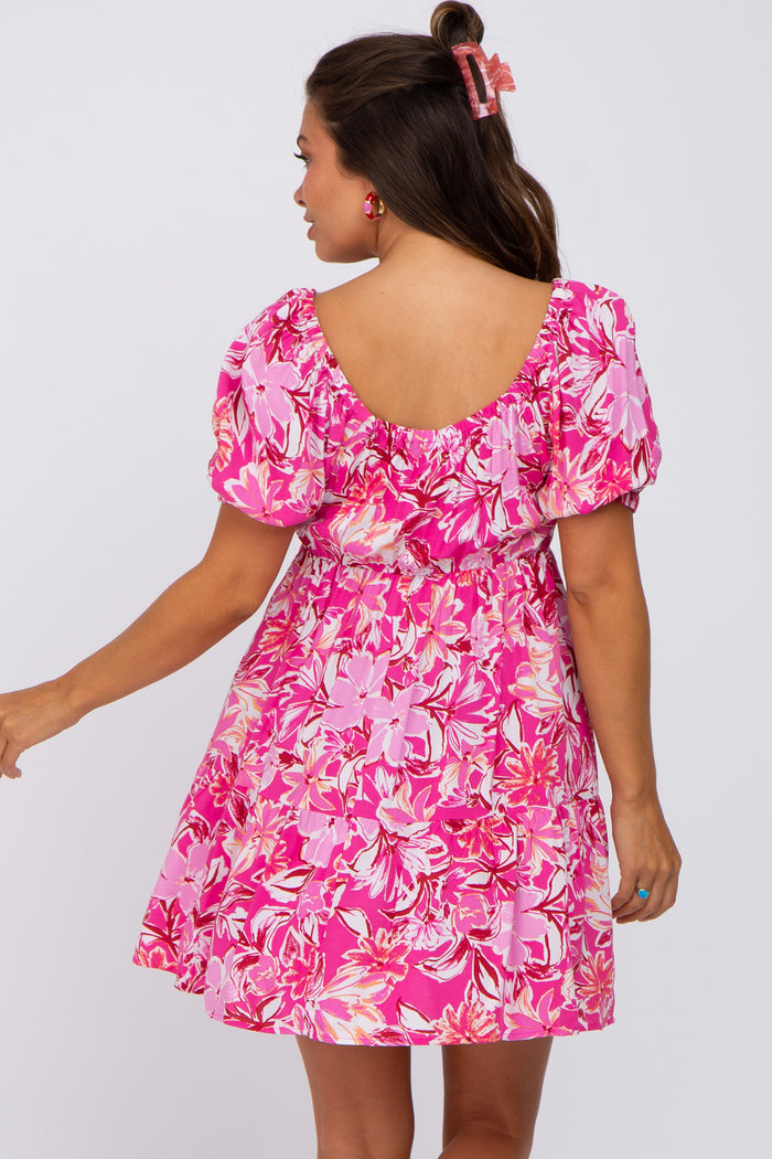 woman wearing a pink floral puff sleeve mini dress with a square back and tiered skirt