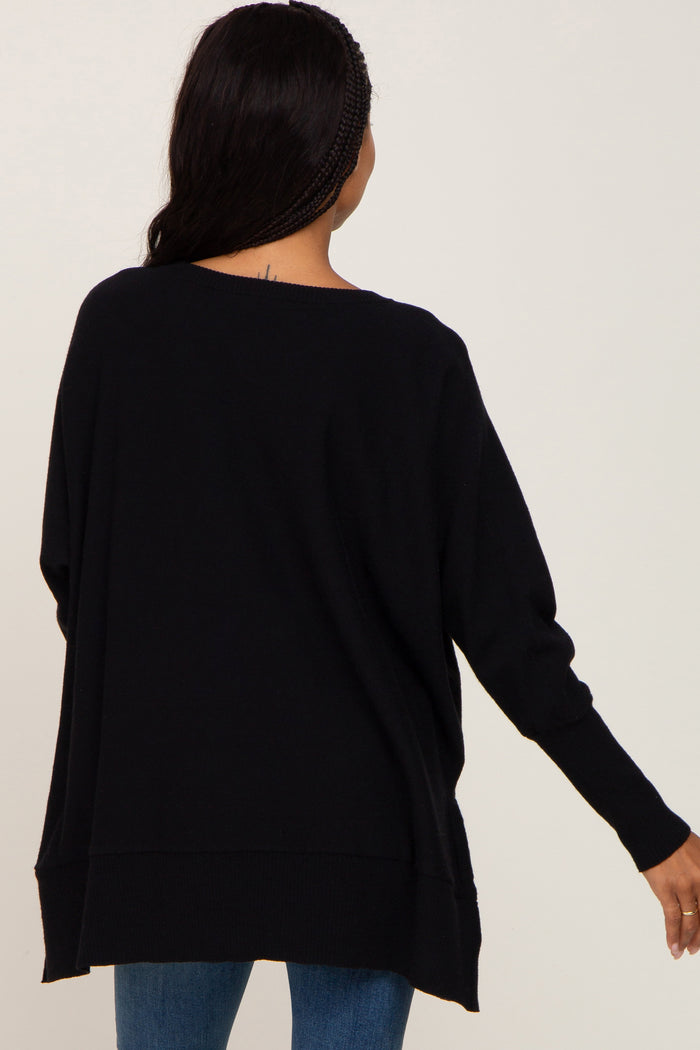 woman wearing a black oversized knit sweater with a relaxed fit and long sleeves