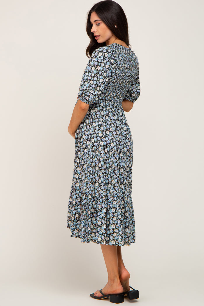 woman wearing a floral patterned maternity dress with a smocked bodice and ruffle hem, showcasing her baby bump