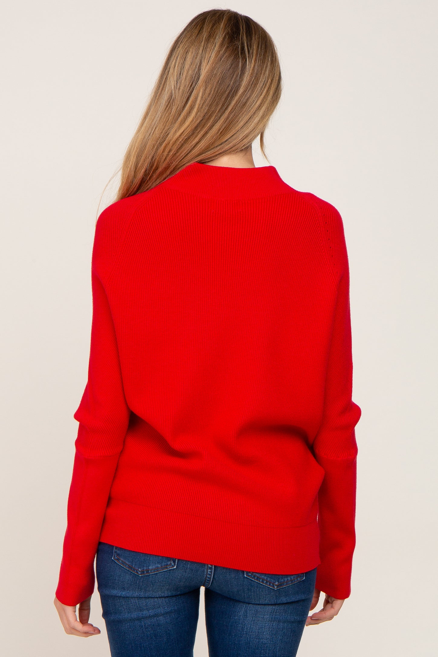 woman wearing a red maternity sweater with a relaxed fit and long sleeves, shown from the back