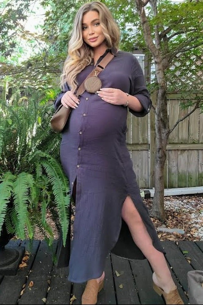 pregnant woman in a long purple button-down maternity dress posing outdoors on a wooden deck
