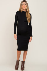 woman wearing a black long sleeve maternity dress that hugs her baby bump