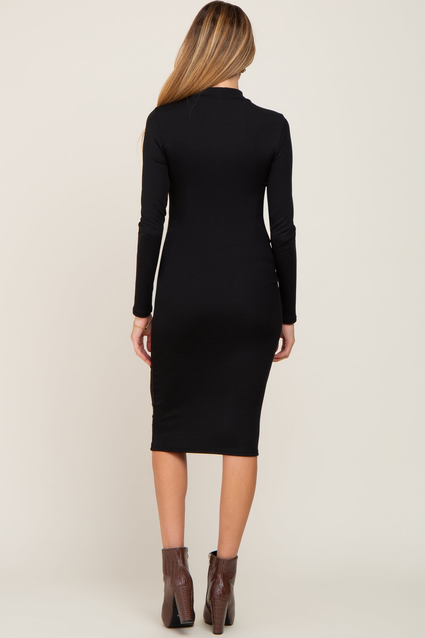 woman wearing a black long sleeve fitted maternity dress, shown from the back