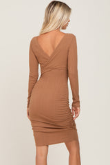 woman wearing a brown long sleeve ribbed dress with a deep v-back and gather detailing on the sides