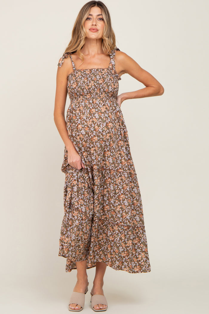 woman wearing a brown floral maternity maxi dress with adjustable straps and a visible baby bump