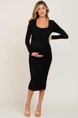 pregnant woman wearing a long sleeve black maternity midi dress with a front tie waist