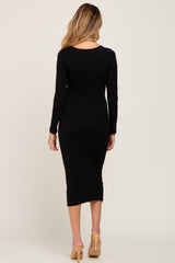 woman wearing a black long sleeve maternity dress, showing a fitted silhouette and midi length from the back