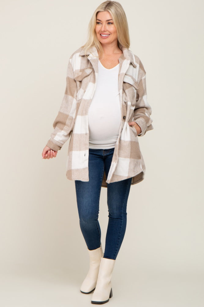 pregnant woman wearing tan plaid maternity shacket with white top and blue jeans