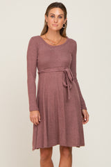 woman wearing a mauve long sleeve ribbed maternity dress with a waist tie and scoop neckline