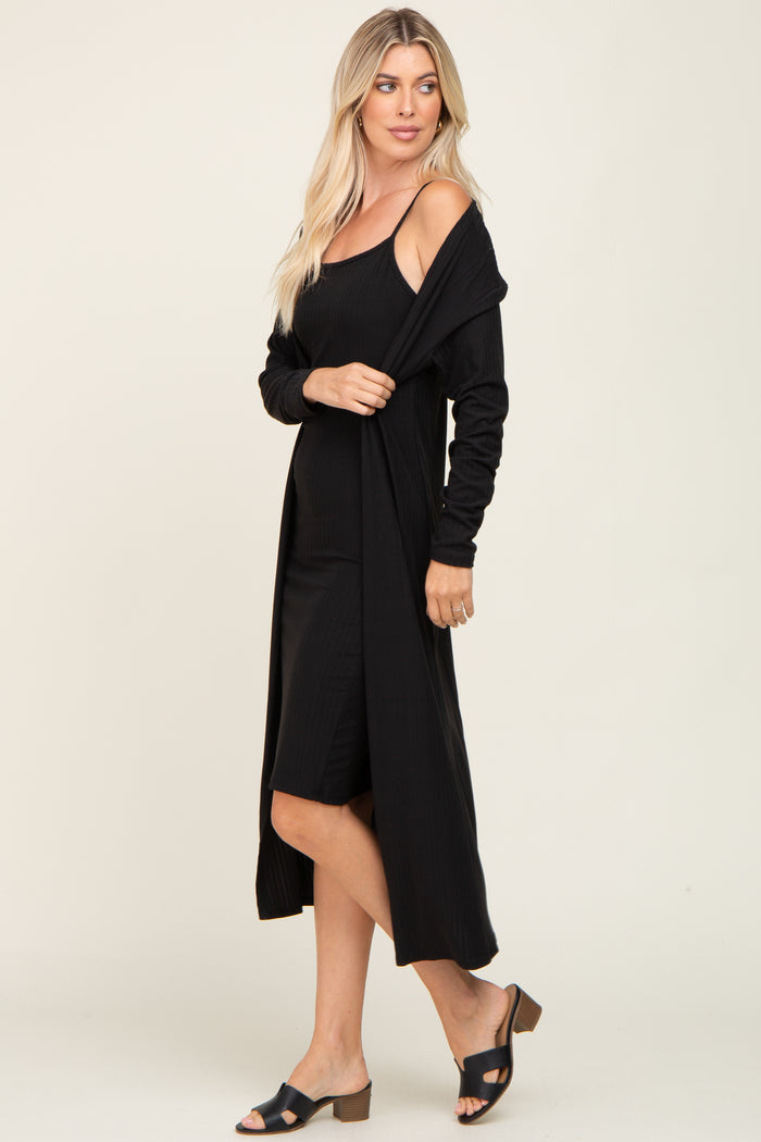 woman wearing a black ribbed midi dress with a coordinating black long cardigan and black heeled sandals
