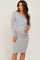 woman wearing a grey long sleeve maternity dress with a crossover design and holding her baby bump