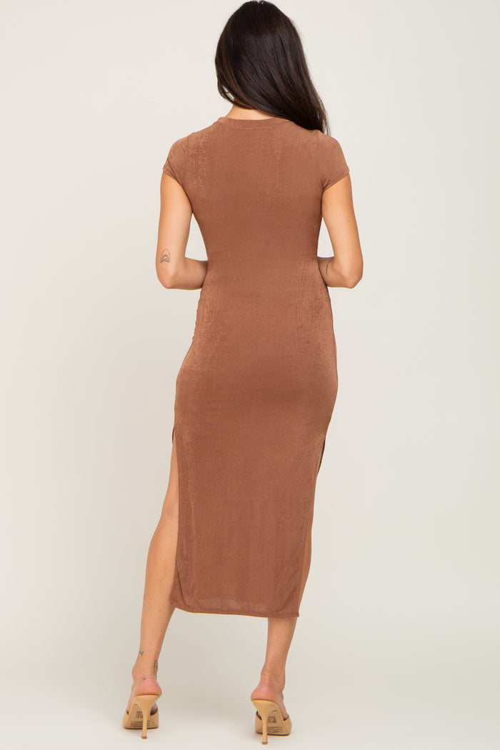 back view of a woman wearing a brown short sleeve midi dress with side slits and tan heels