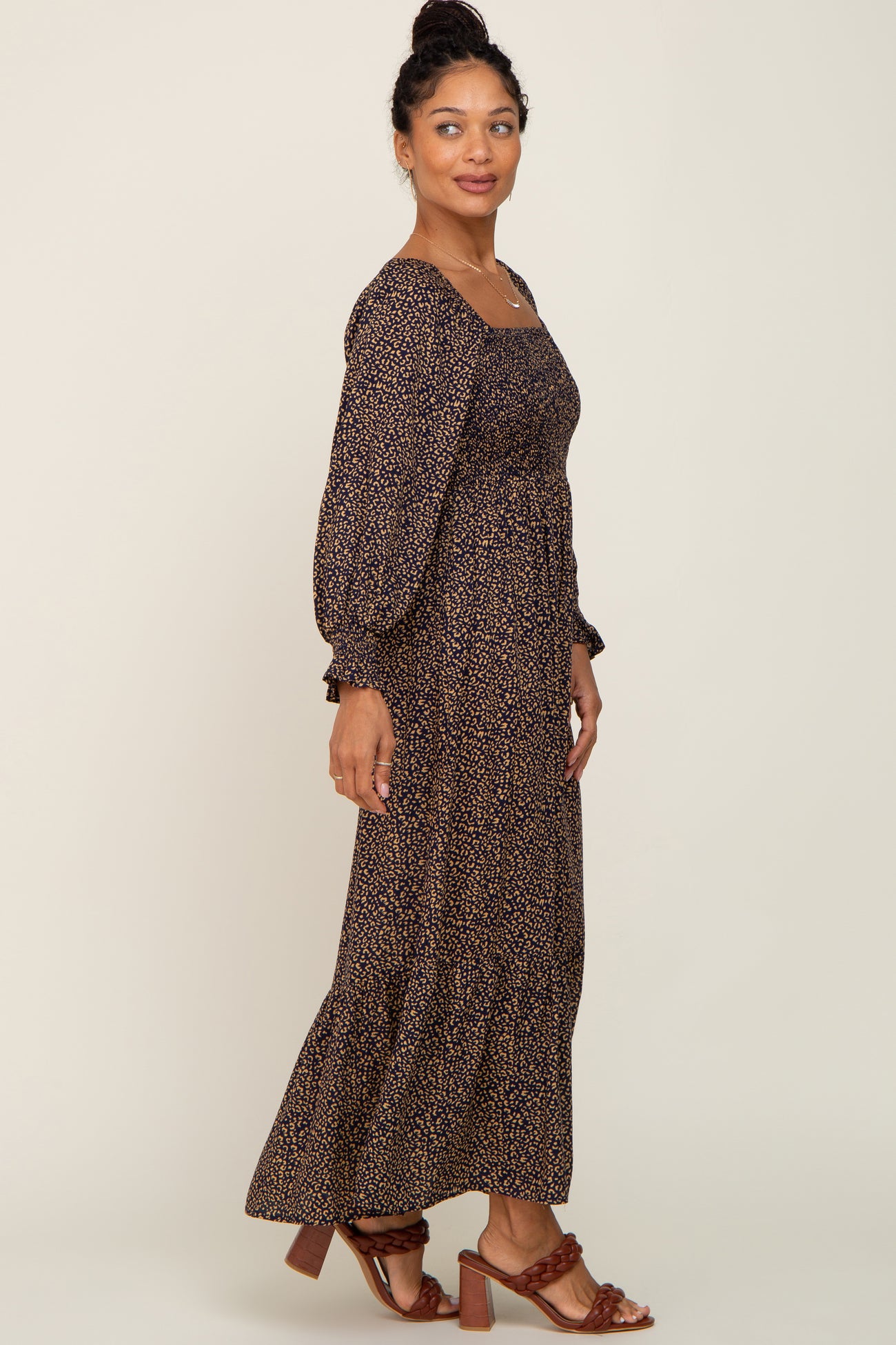 woman wearing a long sleeve leopard print smocked maxi dress and brown braided heels