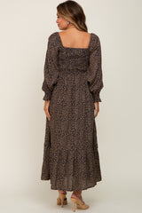 Woman from behind wearing a long sleeve leopard print maxi dress with a smocked back and tiered skirt