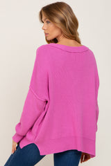 woman wearing a loose-fitting pink oversized sweater with a ribbed texture and dropped shoulders