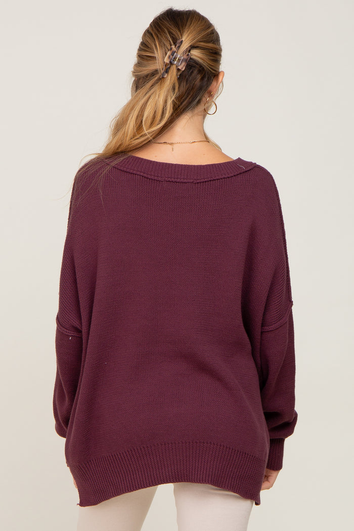 woman wearing a deep burgundy oversized maternity sweater, back view with relaxed fit and drop shoulders