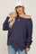 woman wearing a dark purple off-the-shoulder sweater with long sleeves and a relaxed fit, paired with light blue jeans