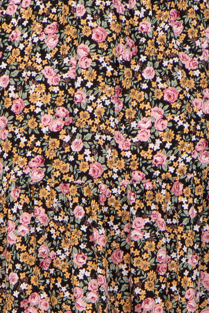 maternity wear featuring a black floral print with pink and yellow flowers on a flowing fabric