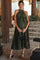 woman wearing a dark green pleated maternity dress with a halter neck and a baby bump, holding a black clutch bag