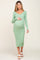woman wearing a green ribbed long sleeve maternity dress and holding her baby bump