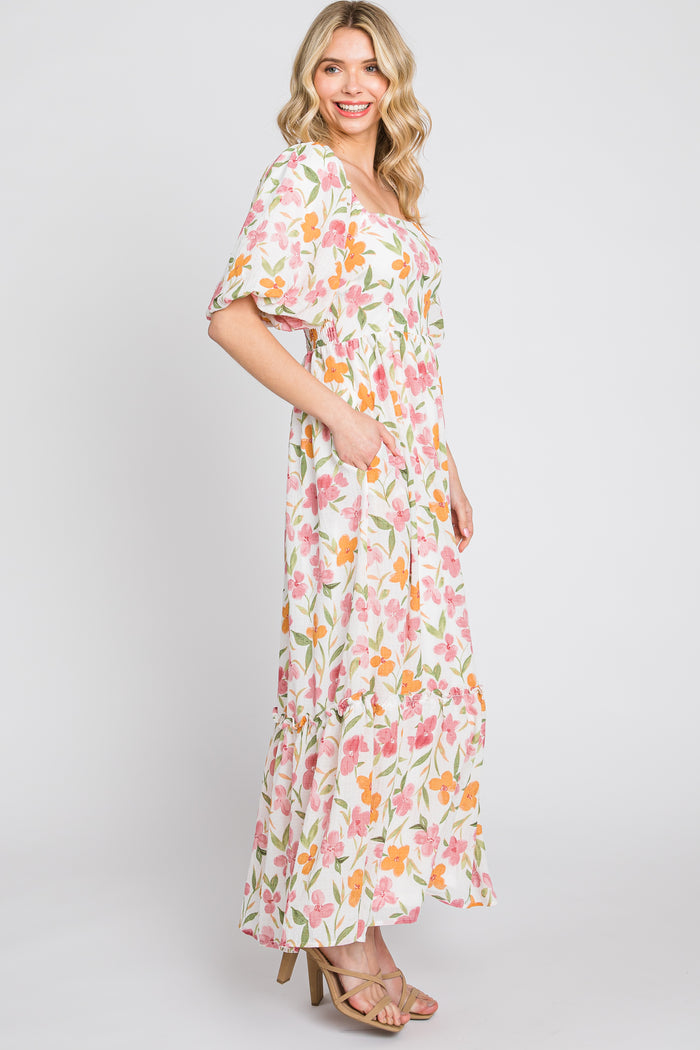 woman wearing a floral maxi dress with a square neckline and short sleeves