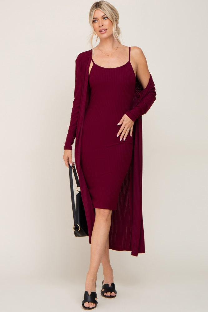 Woman wearing a burgundy ribbed midi dress with a matching long cardigan and black sandals