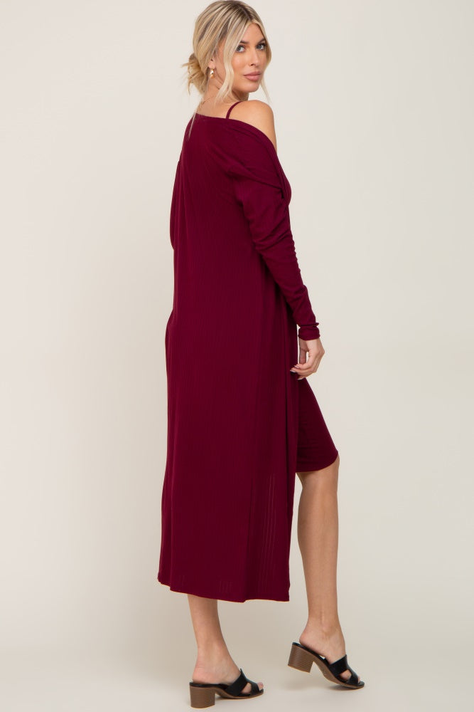 woman wearing a burgundy off-shoulder long cardigan over a fitted dress with heeled sandals