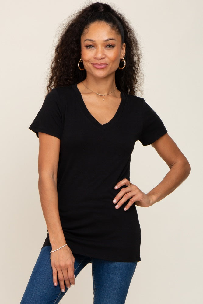 woman wearing a black v-neck short sleeve top with a relaxed fit styled with blue jeans