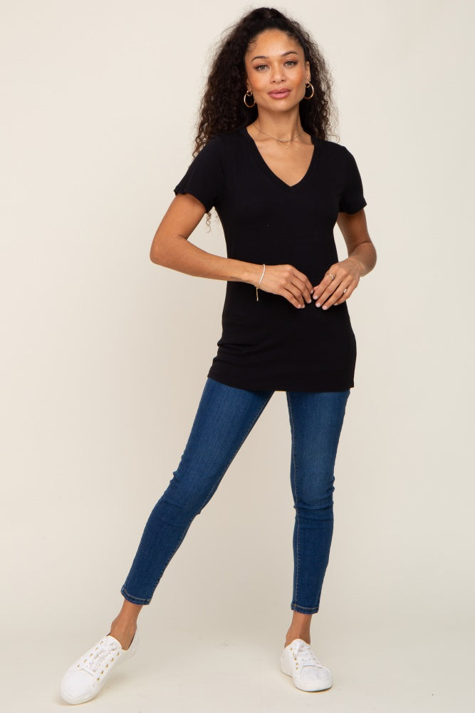 woman wearing a black v-neck short sleeve t-shirt with blue skinny jeans and white sneakers