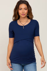 woman wearing a navy blue short sleeve maternity top with a crossover design and visible baby bump
