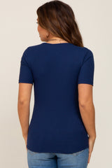 woman wearing a navy blue short sleeve maternity top, shown from the back, paired with light blue jeans