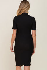 woman wearing a black ribbed maternity dress with short sleeves and scalloped hem, showing her baby bump from the back