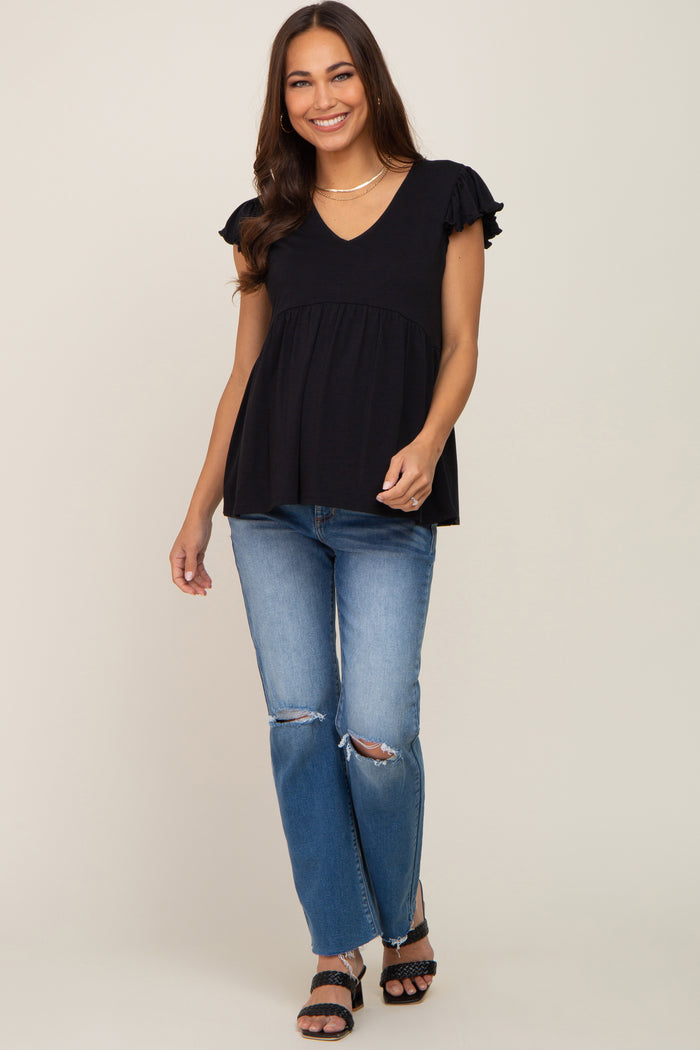 woman wearing a black ruffle sleeve maternity top and distressed blue jeans